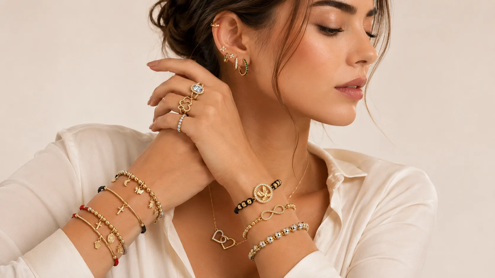 Muñecas con pulseras de símbolos en oro, entre ellas la Pulsera Tejida Águila